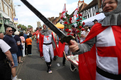Competitors participate in the Pinner Wheelbarrow Race as part of a St. George's Day celebration, in London