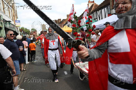 Competitors participate in the Pinner Wheelbarrow Race as part of a St. George's Day celebration, in London