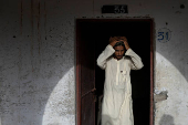 Teen adjusts prayer cap before starting studies at madrasa in Multan