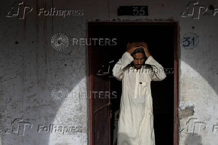 Teen adjusts prayer cap before starting studies at madrasa in Multan