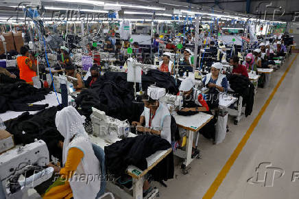 Workers stitch hoodies in a garment manufacturing unit on the outskirts of Ahmedabad