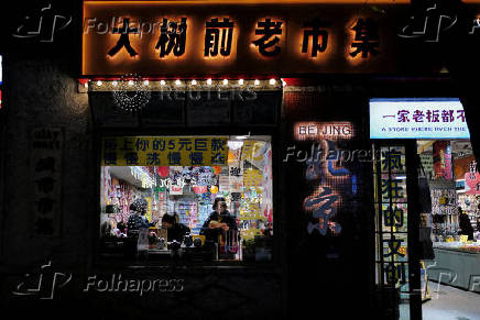 People stand in a shop at the Nanluoguxiang in Beijing