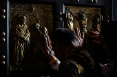 Faithful touch the Holy Door in St. Peter's Basilica at the Vatican
