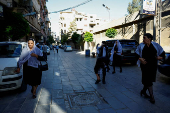 Druze women walk on a street, in Jaramana