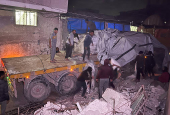 Palestinian workers unload an aid truck, in Khan Younis