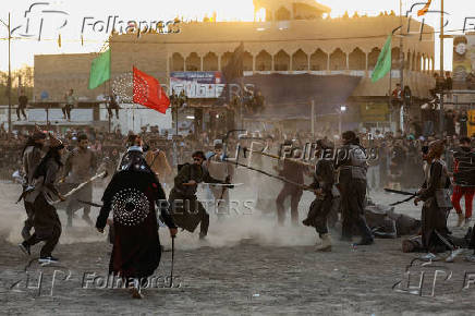 Volunteers re-enact a scene from the 7th-century Battle of Karbala to commemorate Ashura in Baghdad
