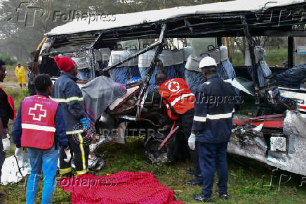 Kenya Red Cross and other rescuers attempt to remove the body of a passenger from the wreckage of a staff bus that collided at a railway crossing in Naivasha