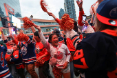 Edmonton Oilers fans react in a fan zone during the first game of the Stanley Cup Finals against the Florida Panthers, in Edmonton