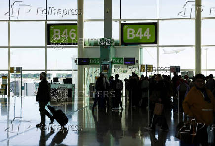 FILE PHOTO: Passengers wait to embark at Josep Tarradellas Barcelona - El Prat airport in Barcelona