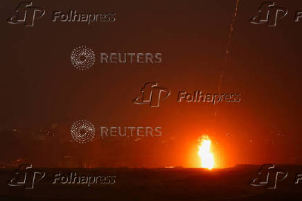 A beam of light is seen resulting from an explosion, as seen from the Israeli side of the Israel-Gaza border