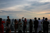 Tourists enjoy during sunset on Mahanakhon Skywalk rooftop in Bangkok