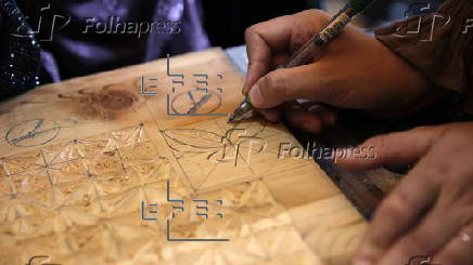 Afghan girl teach Nuristani wood carving skills at a workshop in Kabul
