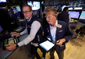 Traders work on the floor at the New York Stock Exchange, in New York City