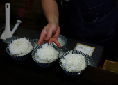 FILE PHOTO: Arata Hirano prepares bowls of cooked California-grown Calrose rice to serve to customers at his restaurant Shokudou Arata in Tokyo
