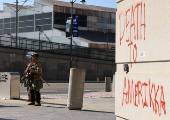 A U.S. Marine and a member of the National Guard stand guard outside the Edward R. Roybal Federal Building, in Los Angeles