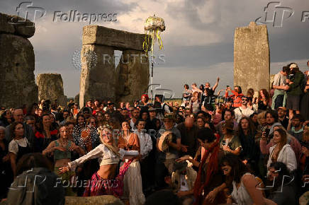 Revellers attend summer solstice celebrations during sunrise at Stonehenge near Amesbury