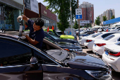 Employee repairs a second hand car at a used car market in Beijing