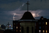Lightning illuminates the sky behind a church in New York