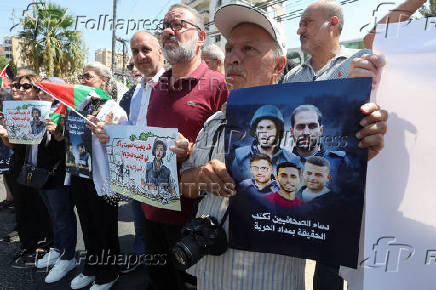 Demonstrators holds posters during a protest in solidarity with journalists in Gaza, in Sidon