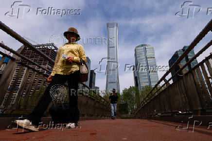 People walk on an overpass at Central Business District (CBD) in Beijing