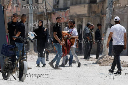 Palestinians carry their belongings after Israel's decision to demolish their homes in Nur Shams camp