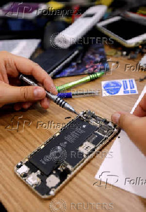 FILE PHOTO: A technician repairs an iPhone in a repair shop in Marseille