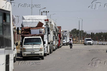 Trucks carrying belongings of Syrian returnees line up at Bab al-Salameh border crossing, in Aleppo's countryside