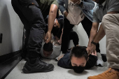 A migrant is detained by federal immigration officers at U.S. immigration court