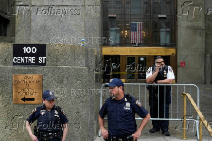 Police officers stand guard outside the Mahattan Criminal Court in New York