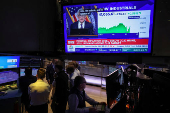 Traders work, as a screen broadcasts a news conference by U.S. Federal Reserve Chair Jerome Powell following the Fed rate announcement, on the floor of the NYSE in New York