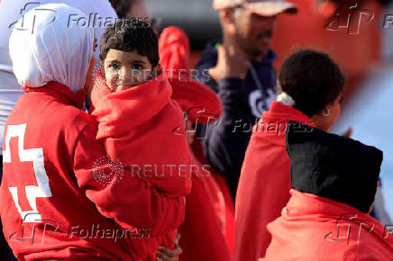 A migrant minor is transferred by the Red Cross after disembarking from a Spanish coast guard vessel, in the port of Arguineguin