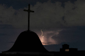 Dry lightning illuminates the sky behind a cross in New York