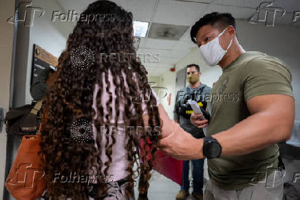 A migrant is detained by federal immigration officers at U.S. immigration court in Manhattan