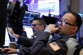Traders work on the floor at the New York Stock Exchange, in New York City