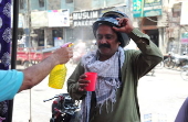 Volunteers distribute cold drinks on a roadside in Hyderabad