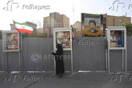 A woman stands on a street in Tehran