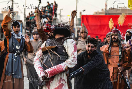 Volunteers re-enact a scene from the 7th-century Battle of Karbala to commemorate Ashura in Baghdad