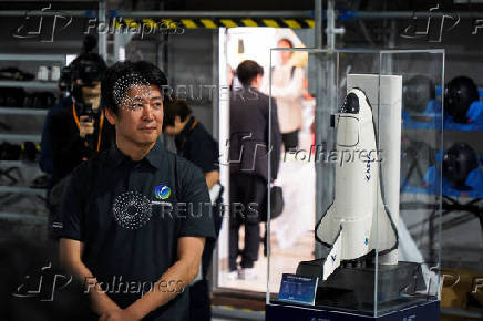 Innovative Space Carrier CEO Hatada poses with a ASCA 3 planned spaceplane model, in Yokohama