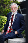 Former Sinn Fein President Gerry Adams sits outside the High Court, in Dublin