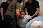 A migrant is detained by federal immigration officers at U.S. immigration court