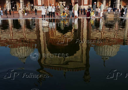 A muslim man performs ablution before offering prayers at Jama Masjid on the occasion of Eid al-Adha, in the old quarters of Delhi