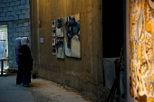 Visitors look at the artwork at the 