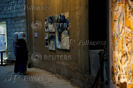 Visitors look at the artwork at the
