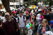 Migrants gather outside the Venezuelan embasssy waiting for a flight back to their country