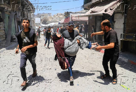 Palestinians evacuate the wounded at the site of an Israeli strike on a house, in Gaza City