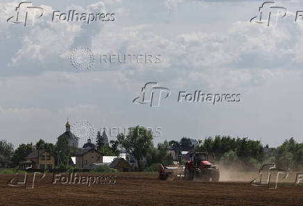 Farmers plant potatoes in a field outside Kolomna, Moscow region