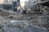 Palestinians inspect the damage at the site of an Israeli strike on a house, in Jabalia