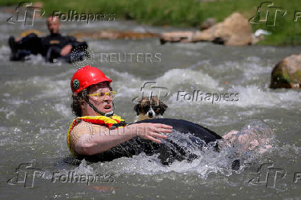 Sports enthusiasts compete while floating on inner tyre tubes during the tyre festival 'Bunar Fest' in Prizren