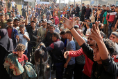 People react as Palestinian casualties, who were waiting to receive aid, are brought into Nasser hospital following an Israeli strike, in Khan Younis