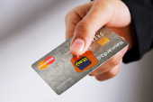 Mão segura um cartão de crétido do banco Itaú da bandeira MasterCard